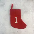 Rode gebreide kerstsok met wit geborduurde letter I op een getextureerde achtergrond - Letter I / 18*15cm