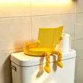 Gelber 3D-gedruckter Toilettenpapierhalter als lesender Partner auf dem Spülkasten - Gelb