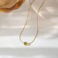 Detail shot of a dainty gold chain necklace with a sparkling green zircon pendant - Gold (N147 Olive Green)