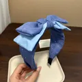 Dettaglio di un cerchietto a fiocco blu fatto a mano con motivo stellato e strati di raso. - Blu scuro
