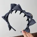 Dettaglio di cerchietto vintage a righe con fiocco e denti antiscivolo per capelli - Fascia Dentata con Fiocco a Righe / Blu nero