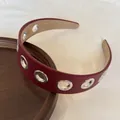 Vista dettagliata del cerchietto in pelle bordeaux stile punk con occhielli d'argento - Rosso