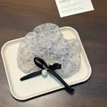 Dettaglio dell'elastico in organza a fiori viola con fiocco nero e ciondolo perla - Pearl Pendant Scrunchie / Scrunchie Floreale Viola
