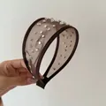 Dettaglio di un lussuoso cerchietto in tulle marrone con strass e borchie scintillanti - Cerchietto in Maglia Marrone con Strass