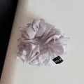 Détail d'un grand chouchou en organza lavande avec une texture de maille brillante - Gris