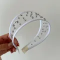 Dettaglio di un cerchietto in rete bianca con strass scintillanti e borchie argentate - Cerchietto in Maglia Bianca con Strass