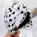 Primo piano del cerchietto in tessuto annodato bianco con motivo a pois neri - Pois Bianchi