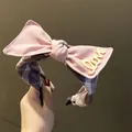 Dettaglio del cerchietto rosa con fiocco, scritta Love gialla e motivo in tessuto plaid - Fiocco Quadri Rosa Coreano (TK21509) / Rosa