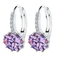 Close-up of elegant silver hoop earrings with sparkling round purple zircons - Purple