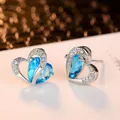 Elegant heart-shaped stud earrings featuring light blue gemstones and sparkling zircon accents - Stud Earrings / Blue