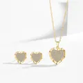 Detaillierte Makroansicht von elegantem Gold-Herz-Schmuckset mit schimmernden Zirkonia-Steinen - Halskette + Ohrringe Set / Gold
