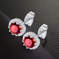 Elegant silver stud earrings featuring a brilliant red round-cut zircon with a halo. - January (Deep Red)