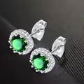 Elegant silver-toned stud earrings featuring a green zircon center with a clear halo stone - May (Green)
