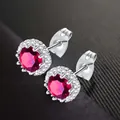 Elegant silver stud earrings with round cut red zircon and halo accents for women - July (Red)