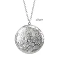 Close-up view of a classic silver round locket necklace with intricate floral engraving - Silver