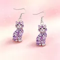 Gedetailleerd overzicht van paarse kristallen kattenoorbellen op een roze achtergrond - Creatieve Stijl (YE-1606) / Paarse Gelukskat
