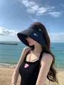 Aziatische vrouw met een zwarte zonnehoed met brede rand op een zonnig strand voor UV-bescherming - M (56-58cm) / Zwart
