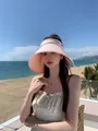 Detailed shot of a pink wide-brim UV protection sun visor on a model at a beach resort - M (56-58cm) / Pink
