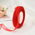 Close-up of vibrant red sheer organza ribbon roll for gift wrapping and DIY crafts. - 450m/Roll (0.6-0.7cm Wide) / Red