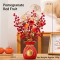 Detail einer roten Glückstaschenvase mit künstlichen Granatäpfeln für die Neujahrsdekoration - Vasenstil - Große Granatapfel-Rote Beeren