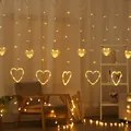 Warm white LED curtain lights featuring hanging hearts in a cozy indoor bedroom setting. - Heart Curtain Light / Plug-in 220V (Standard Controller) / Warm White
