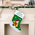 Vista detallada del calcetín de Navidad verde con Papá Noel en un scooter amarillo - Calcetín de Papá Noel