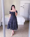 Woman wearing a black polka dot off-the-shoulder tiered midi dress in a bedroom setting. - S / Top And Bottom / Black Polka Dot