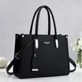 Vista detallada del elegante bolso de mano negro con textura y detalles metálicos plateados - Negro