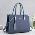 Vista frontal detallada de un bolso de mano azul vintage con asas y correa de hombro - Azul