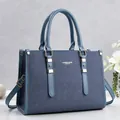 Detailansicht einer blauen Handtasche mit Denim-Textur und feinen Gold-Details - Blau
