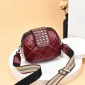 Stylish wine red quilted crossbody bag with silver rivets and wide striped strap - Red
