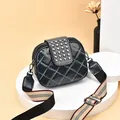 Elegant black quilted crossbody bag with stud detailing and wide striped shoulder strap. - Blue