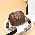 Stylish brown quilted crossbody bag featuring silver rivets and a wide striped strap - Brown