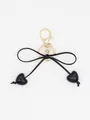 Detailed shot of minimalist black bow keychain with heart charms and gold clasp - Black Heart With Black Rope