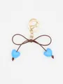 Close-up of a cute blue macaron heart bow keychain with golden clasp and brown cord - Blue Heart With Brown Rope