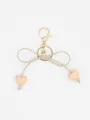 Close-up of a macaron heart bow keychain featuring a golden lobster clasp and key ring. - Beige Heart With Beige Rope