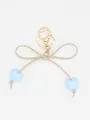 Detail view of a cute macaron heart bow keychain charm with gold clasp on white background. - Blue Heart With Beige Rope