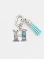 Detail of silver letter H bag charm with turquoise stone and aqua blue tassel - Letter H