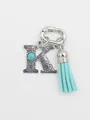 Detail of turquoise letter K keychain with blue tassel and cross engraving - Letter K