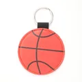 Detail view of a basketball style leather keychain with metal ring on white background - Basketball