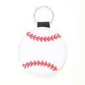 Close-up detail of a round white leather keychain featuring a red baseball stitch pattern - Baseball