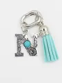 Detailed view of an ethnic style alphabet N charm featuring turquoise and a blue tassel - Letter N