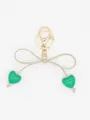 Exquisite keychain featuring a beige bow and two vibrant green heart-shaped charms. - Green Heart With Beige Rope