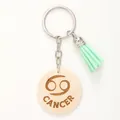 Dettaglio di un portachiavi in legno segno Cancro con elegante nappa verde menta - Cancro / Verde menta
