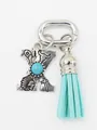 Close-up of ethnic style silver letter X charm with turquoise and aqua tassel. - Letter X