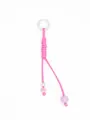 Detailed macro view of a handmade woven pink PU leather keychain with purple beads. - Pink