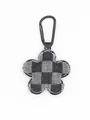 Primer plano de un llavero de flor de mezclilla a cuadros con clip de metal negro para bolso - Cuadros Negros y Blancos (22256)
