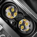 Sunflower and leopard print car coasters placed inside a black car cup holder. - Sunflower Dots Patchwork (80101) / Two-Piece Set