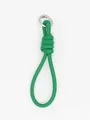 Macro view of the green braided PU leather wrist strap keychain featuring a silver ring - Green