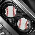 Close-up view of two baseball pattern car coasters inside a black vehicle cup holder. - White Baseball (80103) / Two-Piece Set